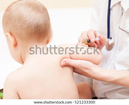 Close-up shot of pediatrician ready to give an intramuscular injection of a vaccine to a baby girl