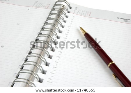 Concept time management, isolated diary and pen on a white background
