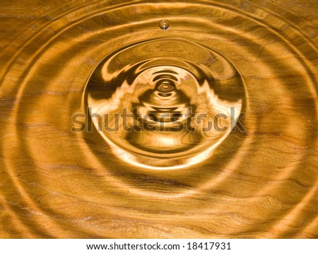 Water droplets and circular ripples on wood