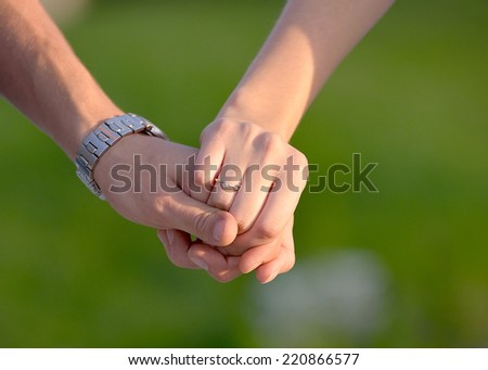 Two hands holding after engagement isolated on green background - stock photo
