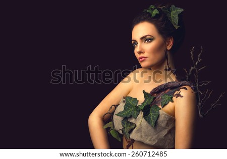 Beautiful woman in concept costume nature forest tree elf on dark background with copy space. Save planet concept.
