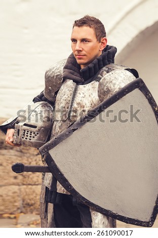 Middle ages brave militant man in ancient knight armor and shield with copy space board