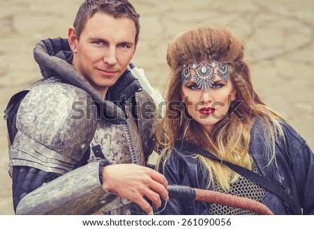 Portrait of middle ages couple of a militant man in ancient knight armor and beautiful blonde woman war princess