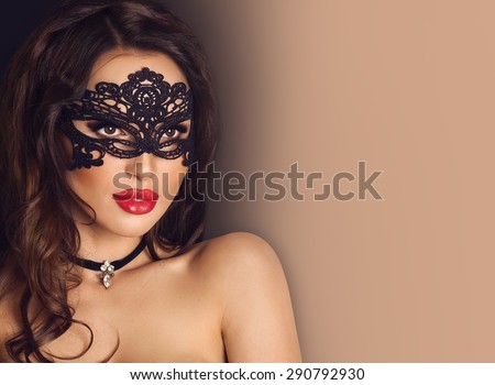 Beautiful Brunette Woman with Black Lace Mask over her Eyes. Red Plump Sexy Lips. Copy space