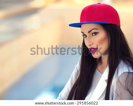 Fashion portrait of a beautiful sporty woman wearing red baseball cap with copy space for your text