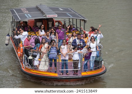 JULY 2012: A tourist boat cruising on Singapore river  in Singapore. Singapore river cruises are popular tourist attractions.