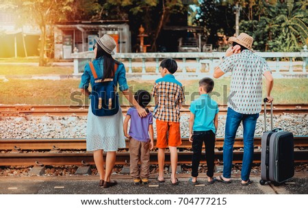 family traveler  looking for train coming.family of Asian travelers go to trip by train.father mother and son waiting for the train come.