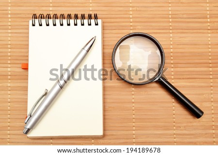 Notepad and magnifying glass