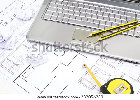 Laptop, meter, pencils and plans