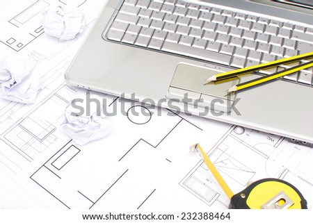 Laptop, meter, pencils and plans