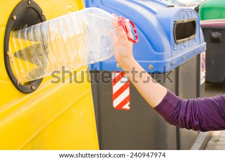 throwing a plastic bottle to recycle container