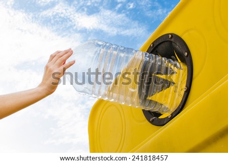 Throwing a plastic bottle to recycle container