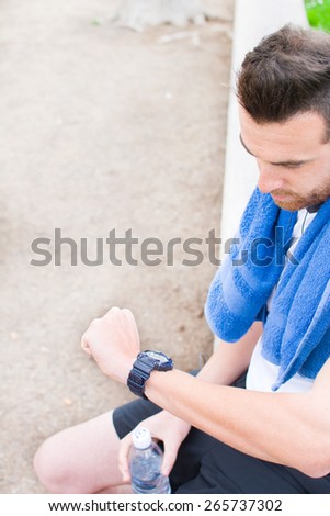 Man doing running and watching the watch in park