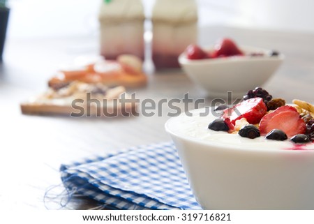Natural yogurt with fresh berries, milk and toast with fruit and cereals