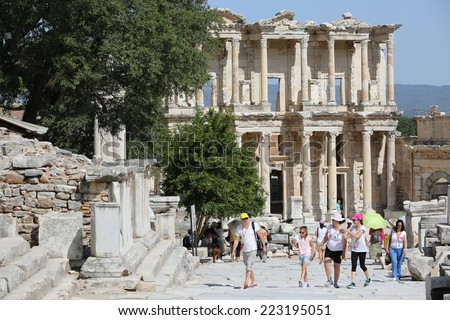 Ephesus, Turkey - June, 26, 2014: A group of tourists gather around a tour guide in the celsus library area of Ephesus in order to hear the guide tell them about the site.