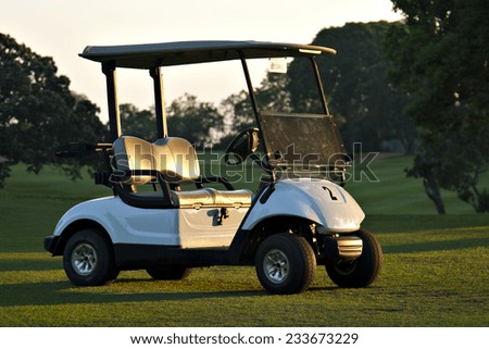A golf cart sits on the fairway of a golf course at a private country club.