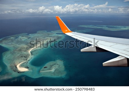 A passenger airliner flies over a set of atolls and islands off Zanzibar, Tanzania, Africa.