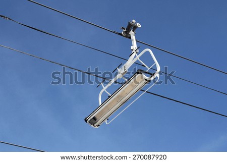 Photo of a chair lift on a mountainous ski resort as used by skiers and snowboarders in winter.