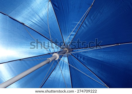 A beach umbrella blocks out the hot, tropical sun.
