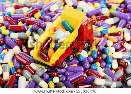 Dump truck toy unload pills and tablets (Installation on the theme of modern medicine)