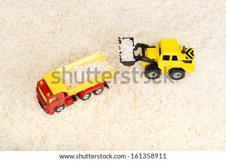 Industrial tractor toy load rice grains to dump truck (installation on the theme of agriculture business)