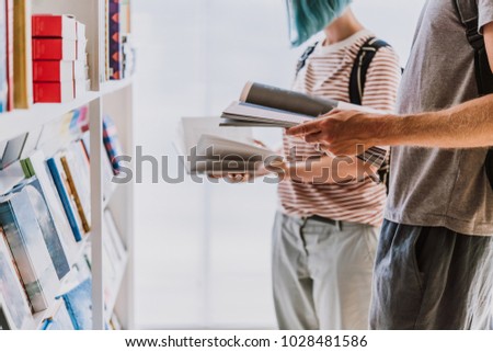 People looking through books at a library or a book store.