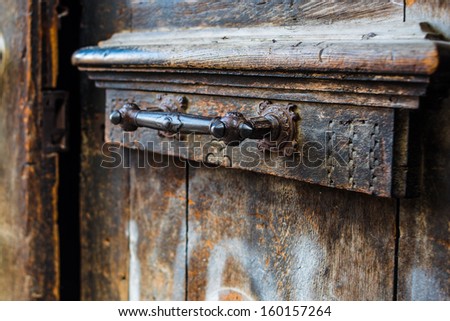 Old wooden door with forged iron ornament