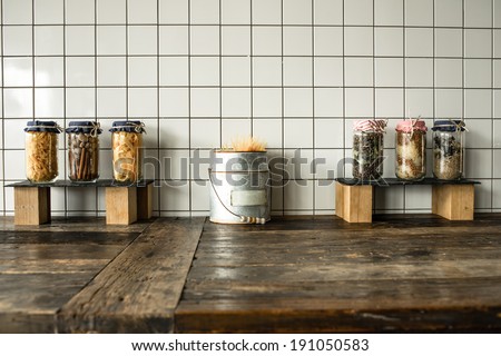Cans with different grocery items on wooden kitchen table
