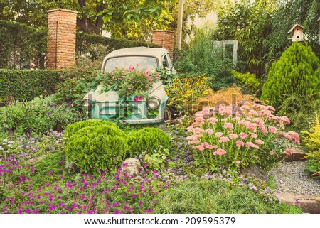 Old car and fields of flowers  in garden. Toned picture