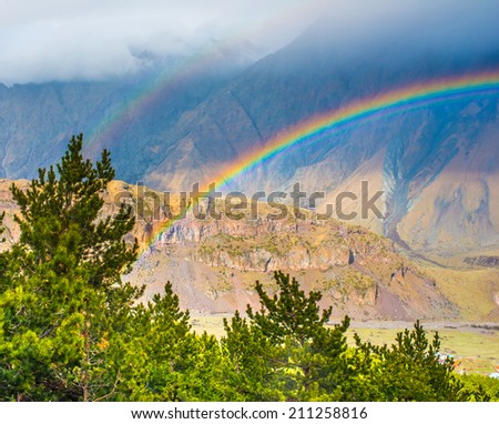 Bright rainbow after rain in Caucasus mountains near Kazbek (Kazbegi), Georgia