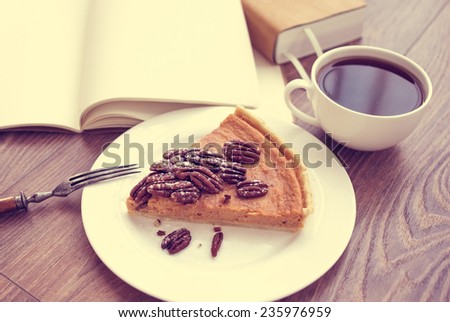 Tea, books and pumpkin cake on wooden background. Toned picture