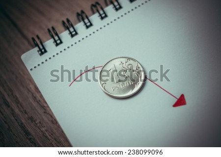 Coin of russian rouble on notepad. Devaluation of the Russian rouble.  Toned picture