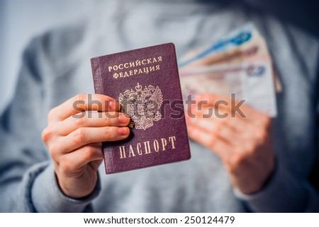 Russian passport and russian rouble bills in hand