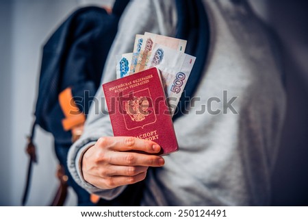 Tourist person holds russian passport and russian rouble bills