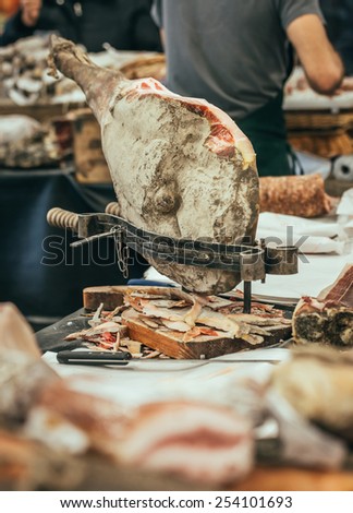 Italian dry-cured ham prosciutto in butchers shop. Toned image