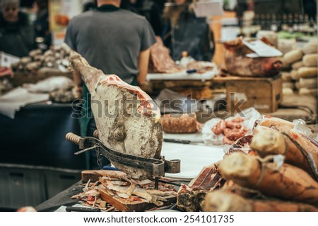 Italian dry-cured ham prosciutto in butchers shop. Toned image