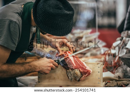 Slicing of italian dry-cured ham prosciutto. Toned image
