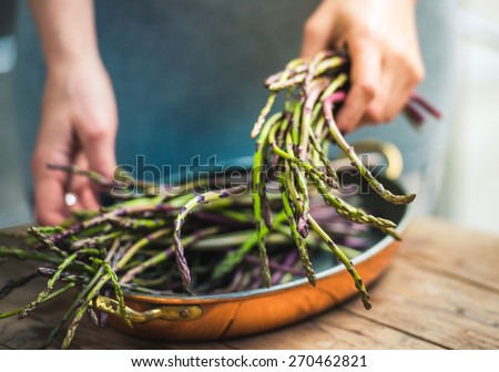 Hands holding a bunch of fresh asparagus. Selected focus and shallow DOF