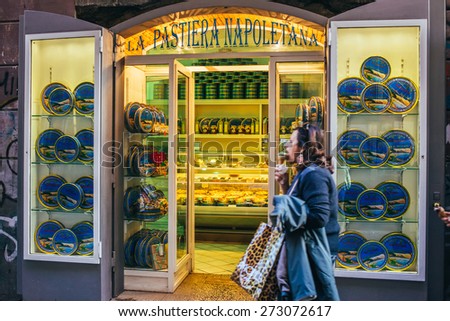 NAPLES, ITALY - MARCH 20, 2015: Woman going near bakery shop with traditional neapolitan cake Pastiera Napoletana in the old center of Naples, Italy. Selective focus