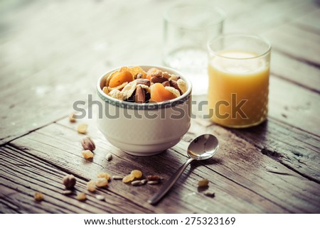 Healthy breakfast on wooden table - cereals, glass of water and  fresh orange juice. Toned image