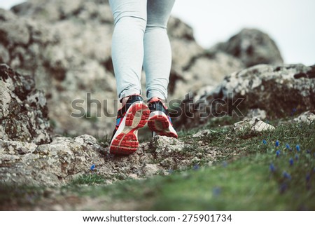 Walking or running legs on trail, adventure and exercising concept. Toned image