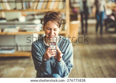 Young beautiful woman sitting with smart phone