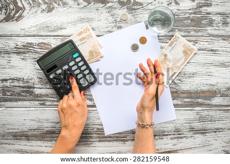 Woman counting euro money with calculator. Business concept. Top view