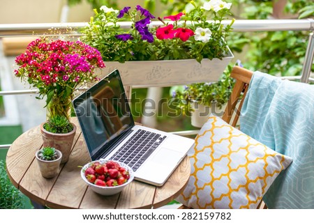 Beautiful terrace or balcony with small table, chair and flowers. Toned image