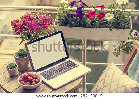Beautiful terrace or balcony with small table, chair and flowers. Toned image