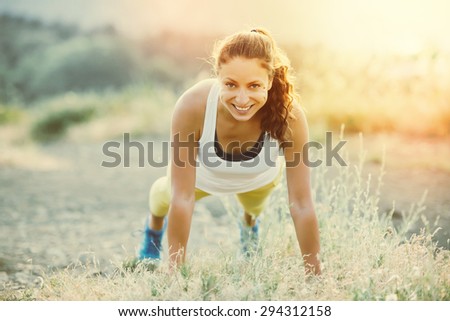Young woman doing push ups workout. Wellness and sport concept. Toned image
