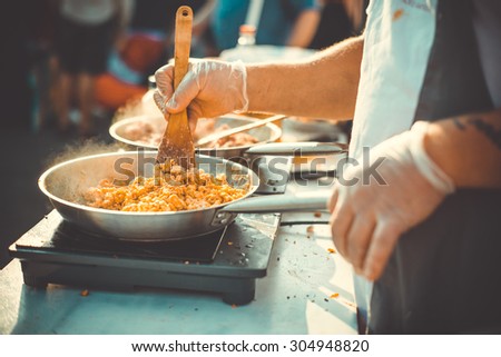 Meat on frying pan. Street food and outdoor cooking concept Toned picture