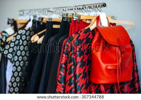 Colorful women\'s dresses on hangers in a retail shop. Fashion and shopping concept
