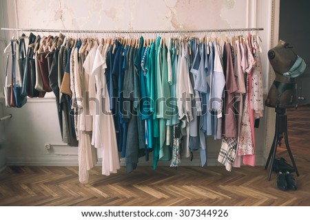 Colorful women\'s dresses on hangers in a retail shop. Fashion and shopping concept. Toned picture