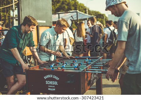 MOSCOW, RUSSIA - AUGUST 9, 2015: Young men are playing kicker at a street fair in Moscow, Russia. Toned picture, vintage film effect